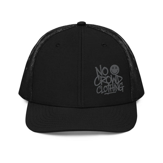 Black trucker hat with mesh back and structured front, designed by No Crowd Clothing, displayed on a plain background..front