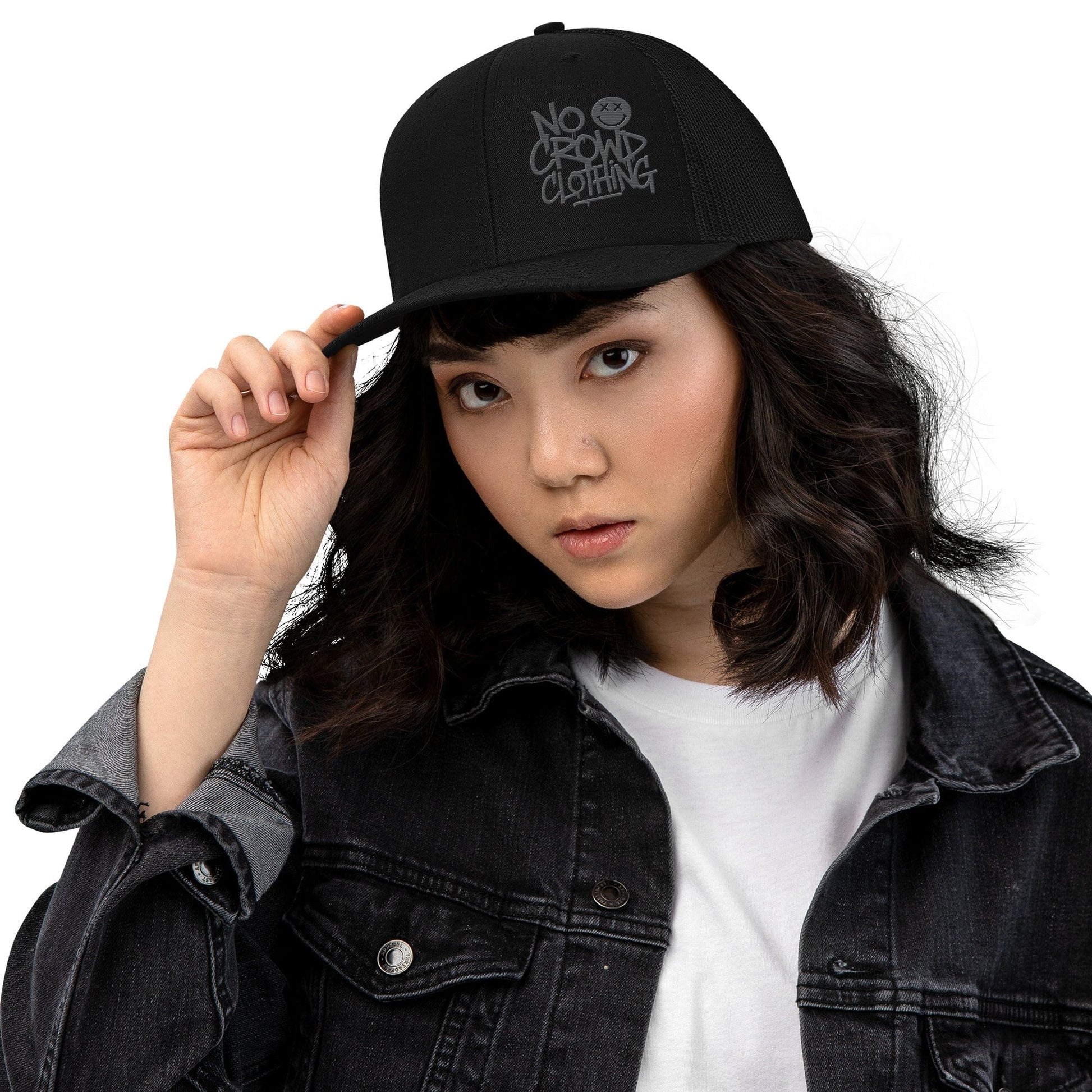 Black trucker hat with mesh back and structured front, designed by No Crowd Clothing, displayed on a plain background...front female model